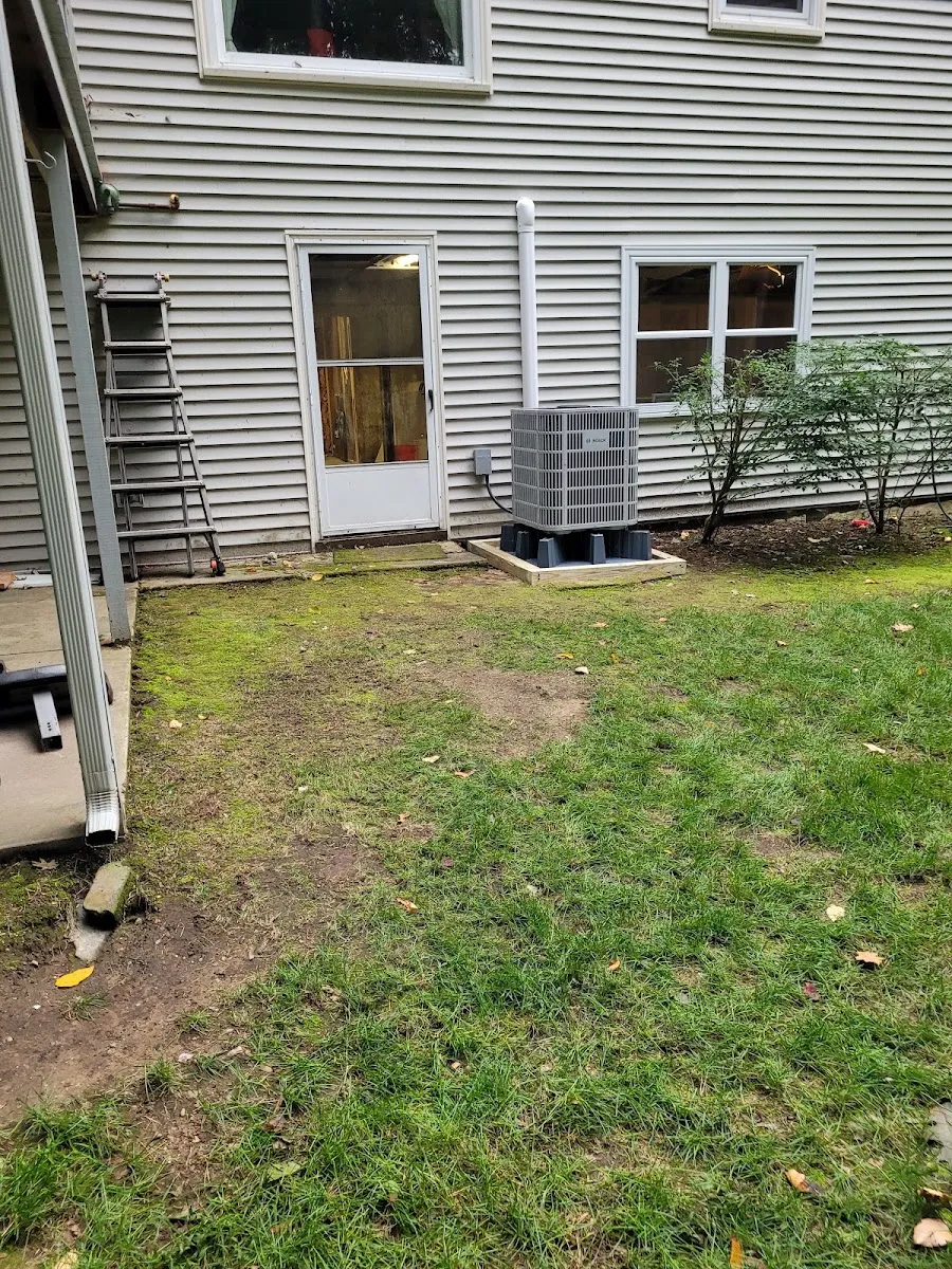 Bosch heat pump condenser — Outdoor heat pump condenser set neatly beside the home with proper electrical disconnect.