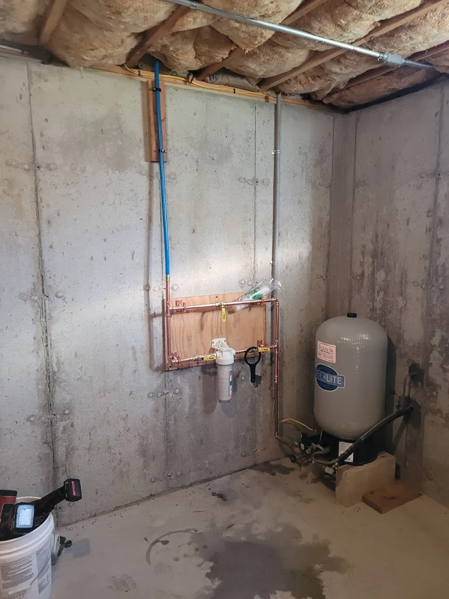 Whole-house water filtration — Clean copper plumbing with a whole-house water filter and pressure tank.